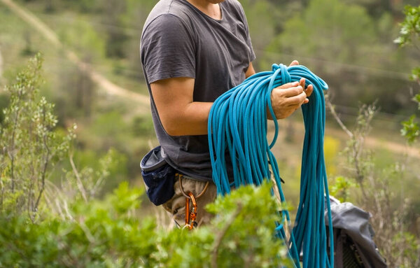 Человек с верёвкой, карабкающийся в горах. Восхождение в горах Испании. Техническое альпинизм.