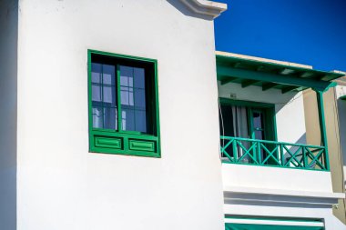 Beyaz bir duvar arka planında parlak yeşil renkli, eski usul ahşap pencere.