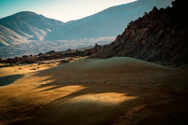 Dağların, kayaların, güneş ışınlarındaki volkanik manzaraların arasında sarı kumlu görkemli bir çöl..