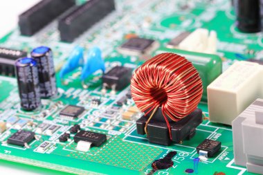 Devre kartındaki bakır bobin veya indüksiyon bobini, bilgisayarın içindeki elektronik bileşenler.