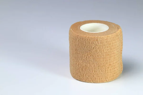 Brown elastic cohesive bandage, Medical cohesive elastic bandage or Flexible Bandage rolled up isolated on white background.