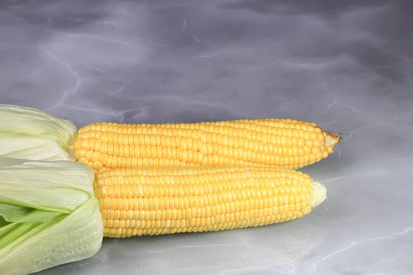 新鲜生玉米芯或玉米穗 绿叶隔离在反射面 — 图库照片