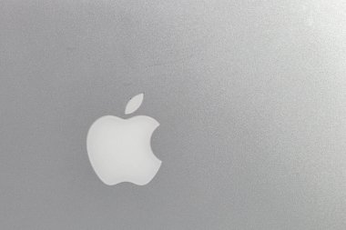 Macbook bilgisayarında elma logosu olan alüminyum patlayıcı dokusu, gümüş gri arka plan..
