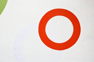 Beyaz beton duvar dokusunda kırmızı renkli daire boyası.