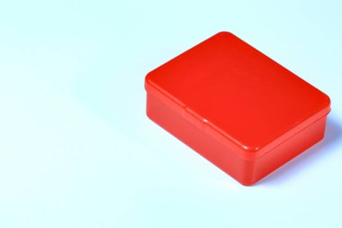 Beyaz arkaplanda izole edilmiş küçük şeffaf kırmızı plastik kutu.