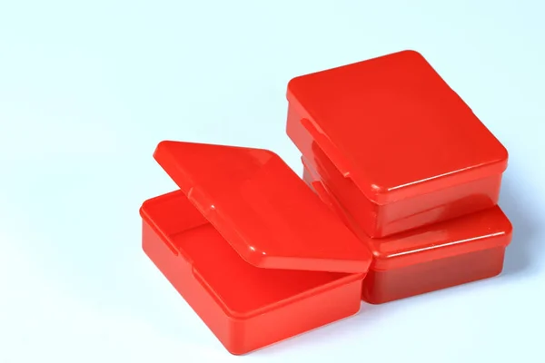 Small transparent red plastic boxes isolated on white background.