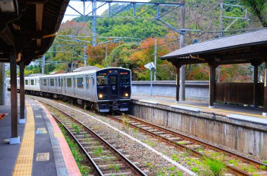 The train approached the platform to pick up passengers at Kidonanzoin-Mae Station. clipart