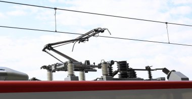 Bir trenin pantografı treni yukarıdaki katenareri teline bağlıyor..
