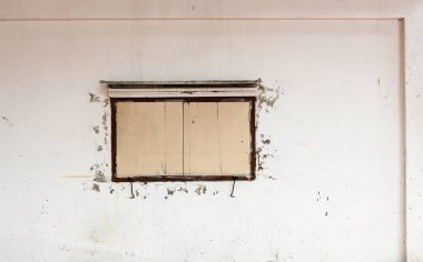 Bej ahşap pencereli tozlu beyaz antik bina cephesi.