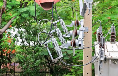 Yüksek gerilim direğindeki yüksek gerilim sigortaları, kapatma düğmesi. Üç aşamalı yüksek gerilimli fitiller çelik kirişlere monte edilmiş. Beton elektrik direğindeki tel bağlantısı..