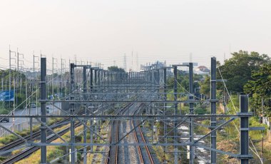 Banliyödeki yüksek güçteki tedarik hatlarına paralel olarak tepeden elektrik direkleriyle donatılmış demiryolu altyapısının havadan görünüşü.
