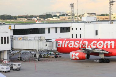 Don-Mueang Airport View, The red-and-white airplane is parked at the passenger gate and connected to it with a jet bridge. clipart