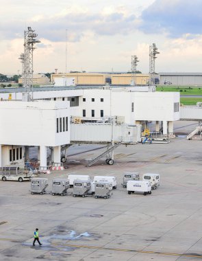 Airport Baggage Tug (baggage dolly transport) on standby in ground handling services. clipart