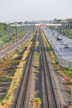 Banliyödeki yüksek güçteki tedarik hatlarına paralel olarak tepeden elektrik direkleriyle donatılmış demiryolu altyapısının havadan görünüşü.