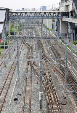 Banliyödeki yüksek güçteki tedarik hatlarına paralel olarak tepeden elektrik direkleriyle donatılmış demiryolu altyapısının havadan görünüşü.