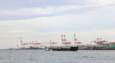 Osaka Japonya 'daki konteynır limanı, kargo konteynır gemisi için endüstriyel limanda konteyner vinci. Modern nakliye konteynır terminalinde kargo taşımacılığı ve aktivite.