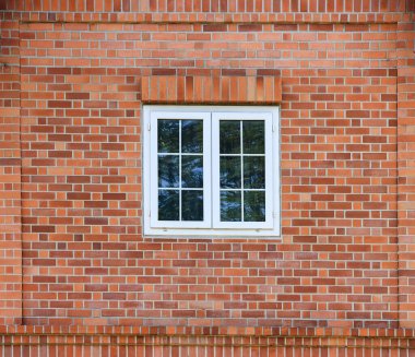 Güzel beyaz ahşap pencereli tuğla cepheden yapılmış bina.