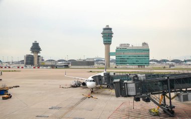 Havaalanı bagaj römorkörü (bagaj taşıyıcısı) görev başında ve yer servis yakıt kamyonu uçak hangarında yakıt ikmali yapıyor.