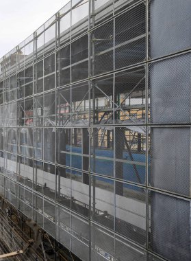 Bir yeniden inşa binasının ön cephesi yenilenme sırasında güvenlik ağlarıyla kaplıydı..