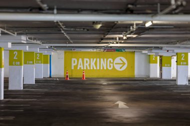 Vacant Parking Lot, dimly lit empty parking garage, parking lot with empty places, Empty Numbered parking lot waiting to be filled with vehicle