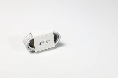 Yeni beyaz USB tipi şarj kablosu, birçok aygıt için uyumlu, sarmal bir şekle bürünmüş, beyaz arkaplanda izole edilmiş.