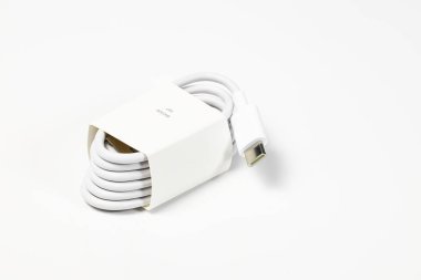Yeni beyaz USB tipi şarj kablosu, birçok aygıt için uyumlu, sarmal bir şekle bürünmüş, beyaz arkaplanda izole edilmiş.