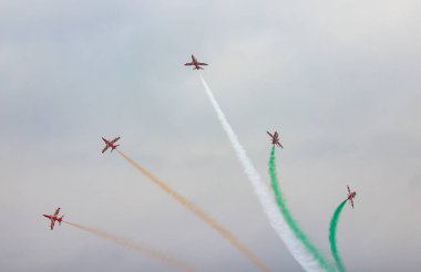 Hindistan Hava Kuvvetleri 'nden HAWK MK132' nin akrobatik hava gösterisi uçaktan renkli dumanlar tüten oluşumlar üzerine.