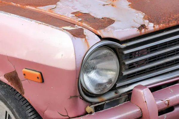 Yolun kenarındaki terk edilmiş eski paslı arabanın farları..