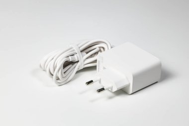 Beyaz arka planda beyaz şarj adaptörü ve beyaz USB kablosu beyaz arka planda izole edilmiş cihazlar için Yeni Şarj ve kablo konnektörü. Teknolojiyi cep telefonlarına yükleme kavramı.