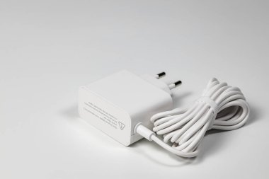 Beyaz arka planda beyaz şarj adaptörü ve beyaz USB kablosu beyaz arka planda izole edilmiş cihazlar için Yeni Şarj ve kablo konnektörü. Teknolojiyi cep telefonlarına yükleme kavramı.