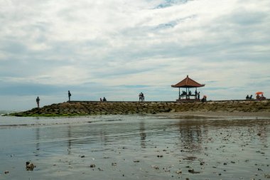 Sanur Plajı, Bali, Endonezya (20 Şubat 2021): Sanur plajının atmosferi, dinlenmek ve güneşin doğuşunu izlemek için gelen insanların faaliyetleriyle dolu.