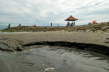 Sanur Plajı, Bali, Endonezya (20 Şubat 2021): Sanur plajının atmosferi, dinlenmek ve güneşin doğuşunu izlemek için gelen insanların faaliyetleriyle dolu.