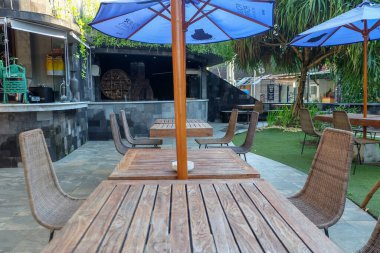 Kuta, Bali, Endonezya (13 Mayıs 2021): Yemek masaları ve sandalyeler bahçede düzgünce düzenlenmiştir. Misafir kullanımı için hazırlanıldı.