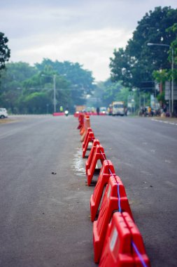 Denpasar, Bali, Endonezya (18 Temmuz 2021): Ayırıcılar araç faaliyetlerini ve hareketliliğini sınırlamak için yolun ortasına yerleştiriliyor. COVID-19 salgınının yayılmasının önlenmesi