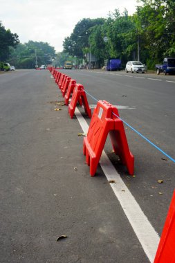 Denpasar, Bali, Endonezya (18 Temmuz 2021): Ayırıcılar araç faaliyetlerini ve hareketliliğini sınırlamak için yolun ortasına yerleştiriliyor. COVID-19 salgınının yayılmasının önlenmesi