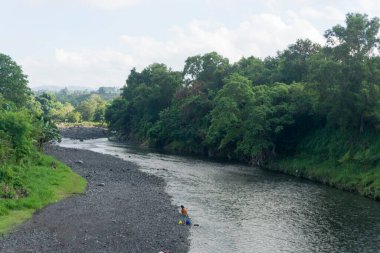 Klungkung 'daki Yeh Unda nehrinin doğal manzarası. Nehir ağaçların arasından akar..