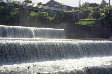 Barajı ve küçük köprüsü olan nehir manzarası. Tukad Yeh Unda Barajı, Klungkung, Bali.