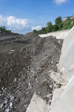 İnşaat alanı taş ve kum yığınlarıyla dolu.