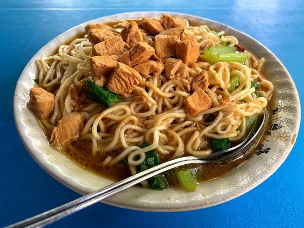 Üzerine doğranmış tavuk ve ıspanak sebzesi konmuş tavuk eriştesi. Cakarta 'nın tipik Tavuk Eriştesi. Adı 