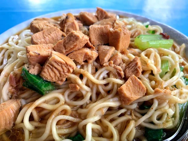 Üzerine doğranmış tavuk ve ıspanak sebzesi konmuş tavuk eriştesi. Cakarta 'nın tipik Tavuk Eriştesi. Adı 