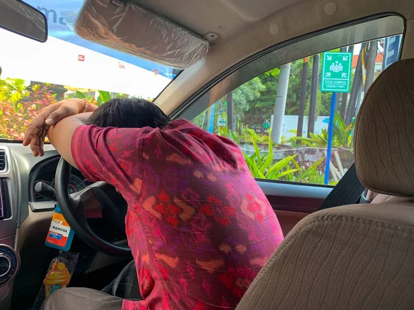 stock image Sanur, Bali, Indonesia (March 9, 2021) : A driver is resting in a car, after a day of driving around the city of Denpasar