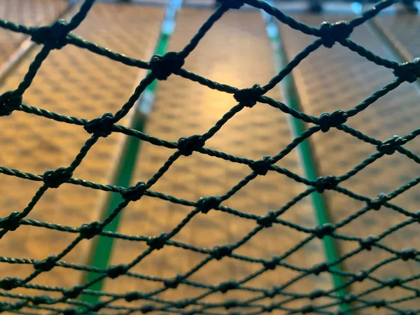 Safety net on the playground. Close up view of the nets against a wooden floor background