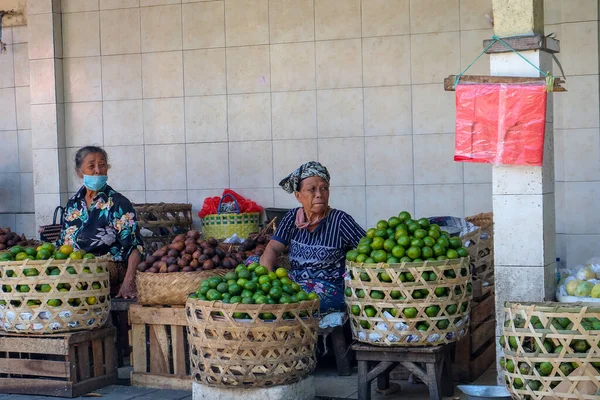 Kumbasari Pazarı, Bali, Endonezya (2 Nisan 2021): Denpasar geleneksel pazarında bir meyve satıcısı müşteri bekliyor. Satılan meyveler; salak, portakal, kepundung, ejderha meyvesi ve silikat. .