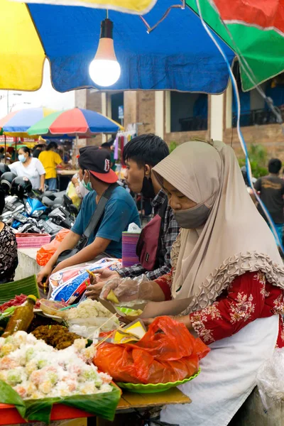 Denpasar, Bali, Endonezya (19 Haziran 2021): Denpasar geleneksel pazarı. Yaşlı kadın tüccar geleneksel pazarda mallarını bekliyor.