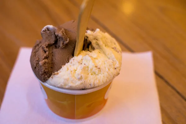 Tahta bir masada yemeye hazır bir fincan dondurma. Tatlı ve tatil konsepti için harika bir illüstrasyon.