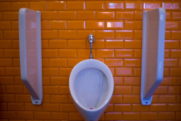公衆トイレのトイレにあるトイレのトイレです オレンジ色の壁を持つ白い色 — ストック写真