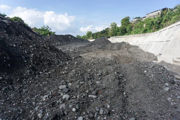 İnşaat alanı taş ve kum yığınlarıyla dolu.