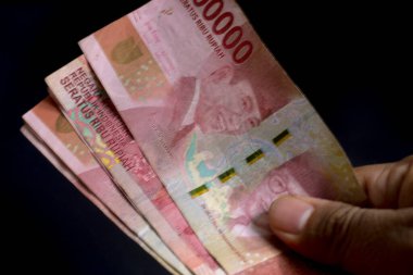 Sağ el bir tomar para verdi. Endonezya Rupiası. Hayır işi için güzel bir illüstrasyon. Finans ve ticari işlemler için iyi bir kavram