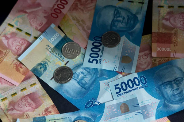 Bozuk paralar ve kağıt paralar siyah arka plana saçılmış. Endonezya Rupiası ekonomi konsepti için iyidir. Bozuk para çizimi. fiat para.