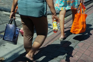 Sanur, Bali (23 Ekim 2022): Farklı nesillerden üç kadının sokakta yürüdüğünü görüyorsunuz